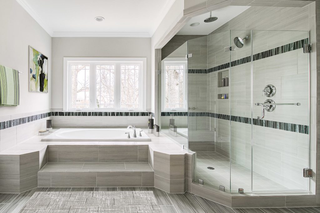 Owners suite bathroom with a tub, shower, and window for added natural light.